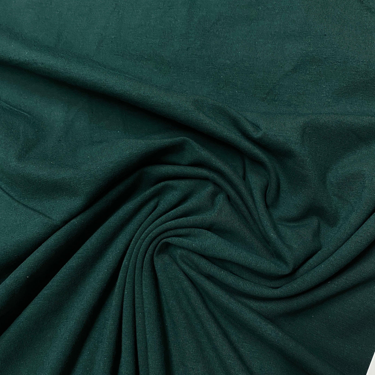 Dark green organic cotton fabric draped in folds from Nature's Fabrics