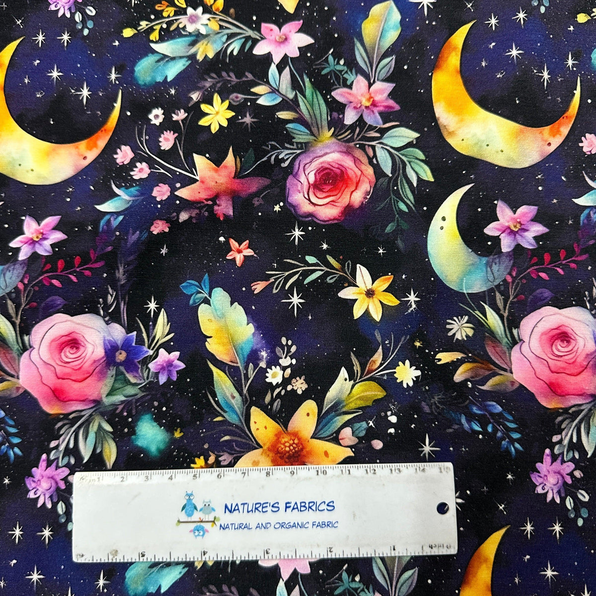 Nature's Fabrics organic cotton fabric with celestial moons and floral print on dark navy background