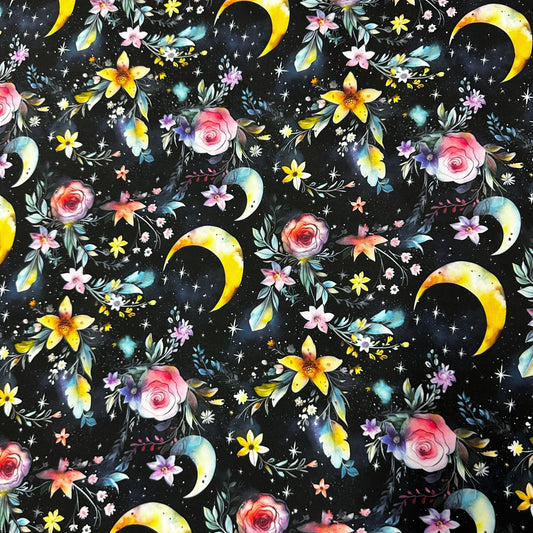 Nature's Fabrics celestial pattern fabric with yellow moons, pink roses, and gold stars on black.