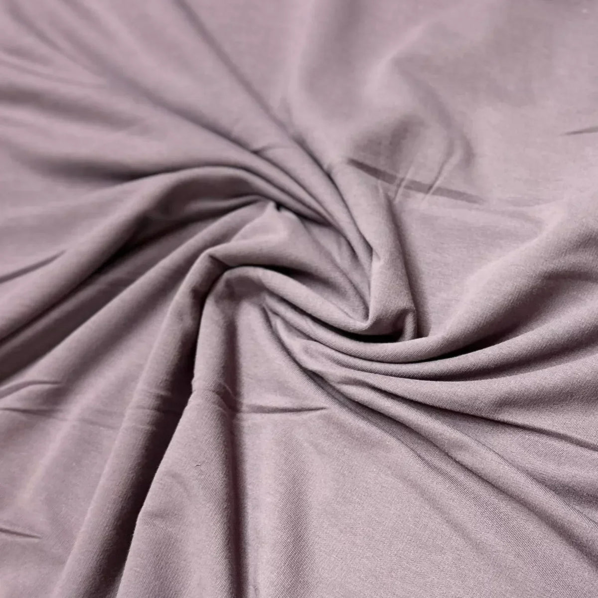 Nature's Fabrics premium dusty purple organic fabric draped in soft folds.