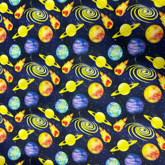 Nature's Fabrics space-themed print with colorful planets, stars, and comets on navy blue.