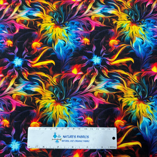 Nature's Fabrics rainbow psychedelic swirl print fabric with a ruler for scale.