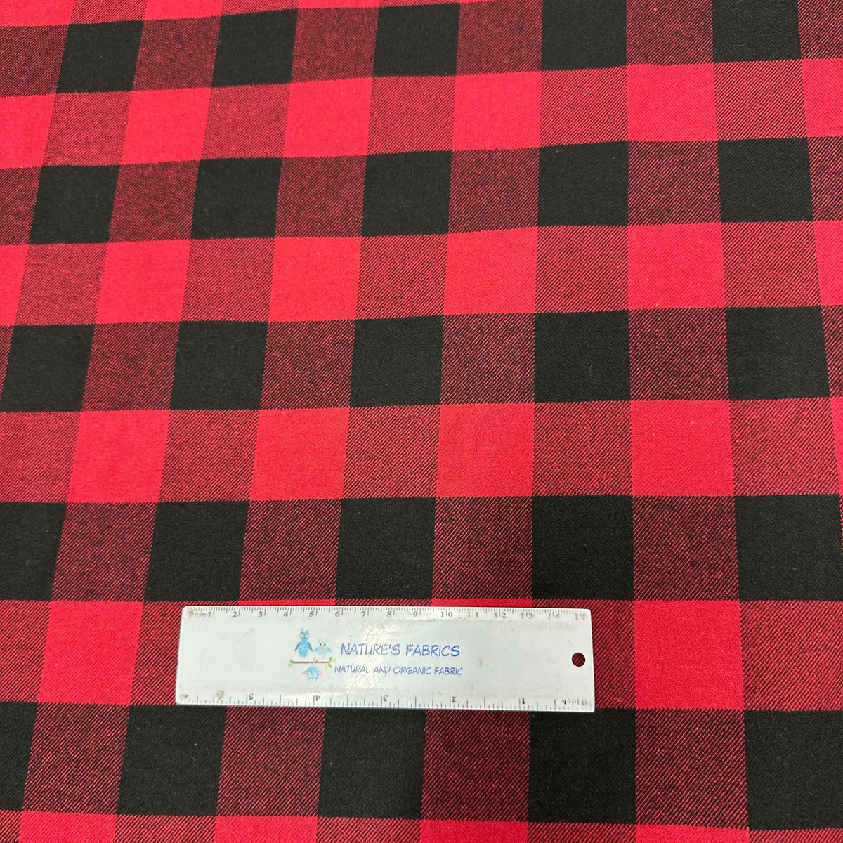 Red and black buffalo plaid fabric from Nature's Fabrics with a ruler for scale.