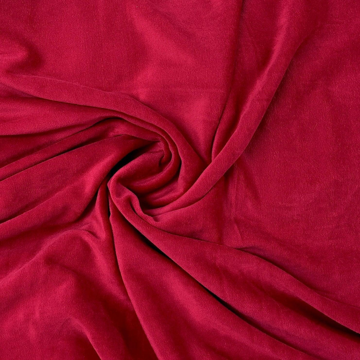 Red organic fabric by the yard from Nature's Fabrics, swirled in a soft drape.