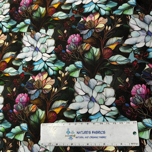 Nature's Fabrics organic fabric featuring a stained-glass style floral print on black background.