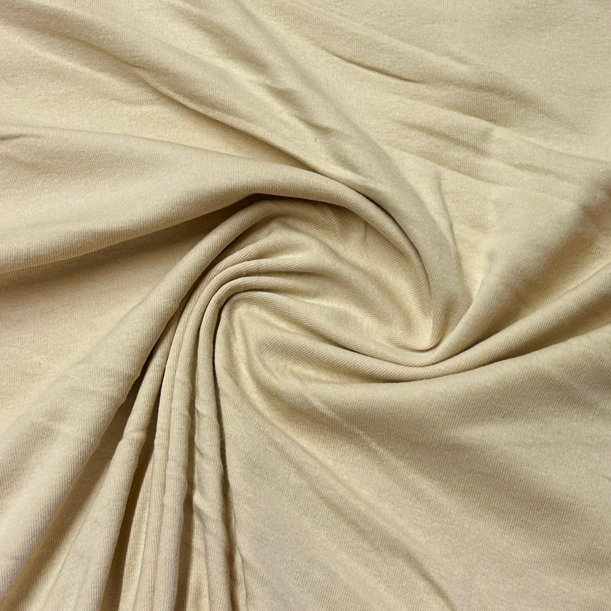 Close-up of draped cream-colored organic cotton fabric from Nature's Fabrics.