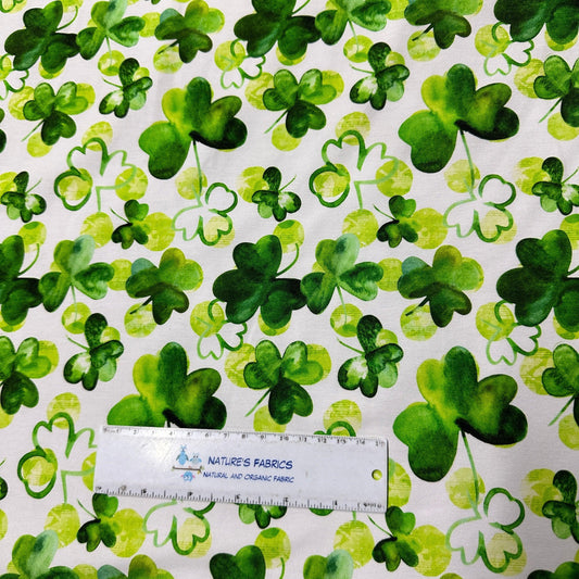 Green shamrock pattern organic cotton fabric by Nature's Fabrics with a ruler for scale