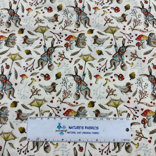 Nature's Fabrics organic cotton fabric featuring illustrated rabbits, birds, and mushrooms.