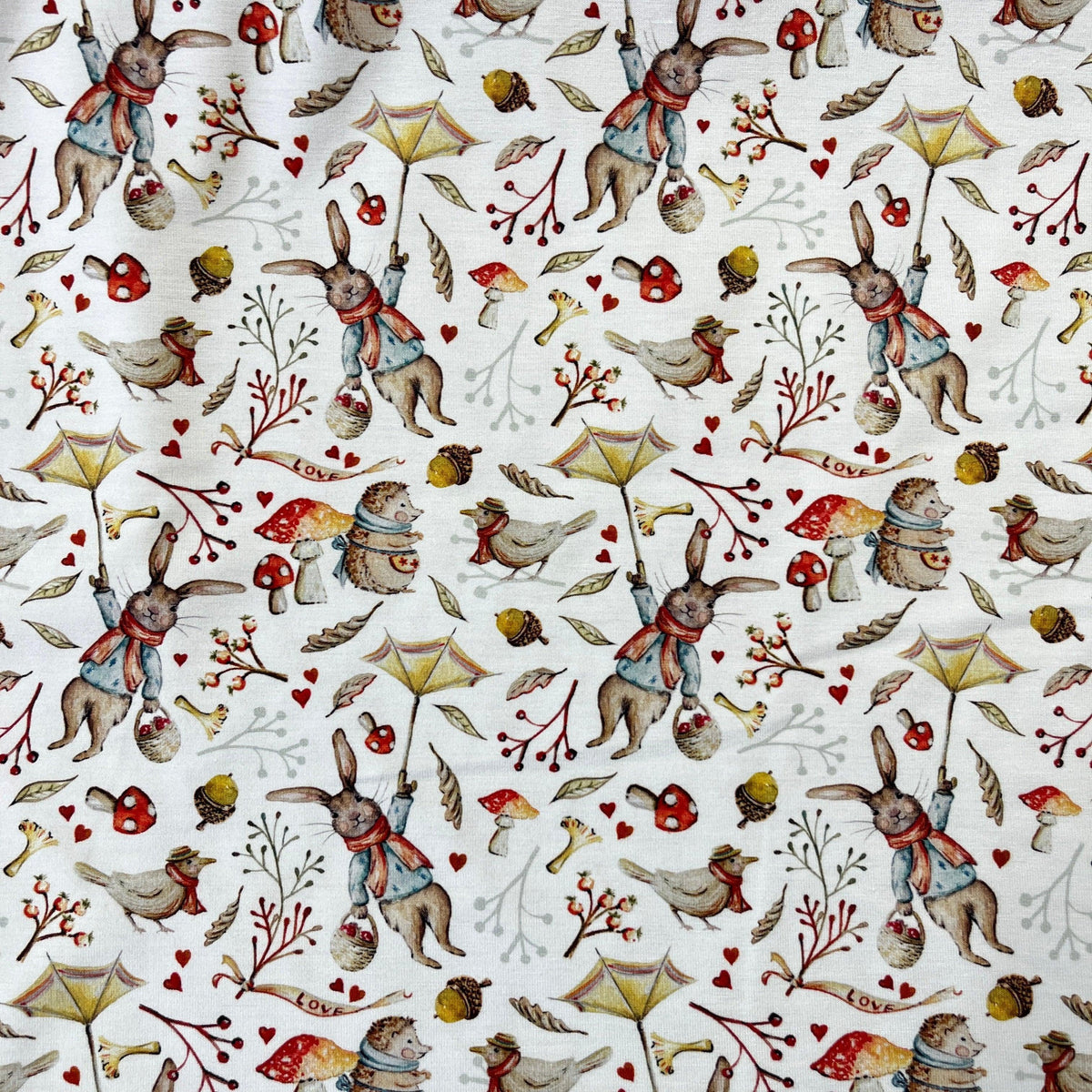 Nature's Fabrics white cotton fabric with illustrated rabbits, birds, and mushrooms print