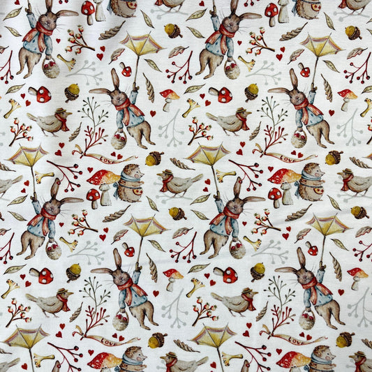 Nature's Fabrics white cotton fabric with illustrated rabbits, birds, and mushrooms print