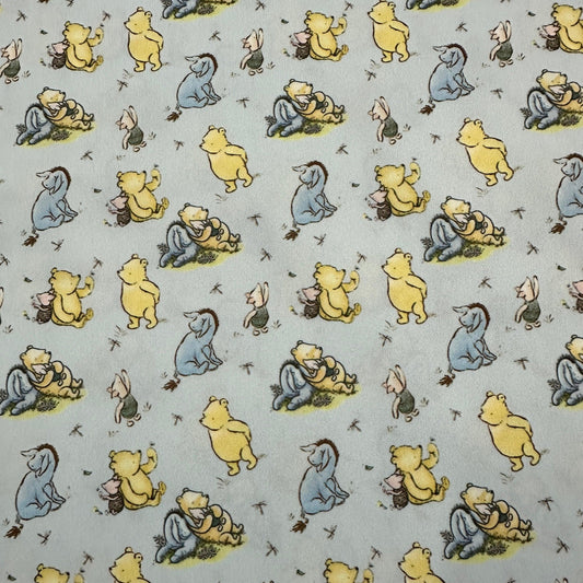 Nature's Fabrics cotton fabric featuring a repeating pattern of Winnie the Pooh and Eeyore.