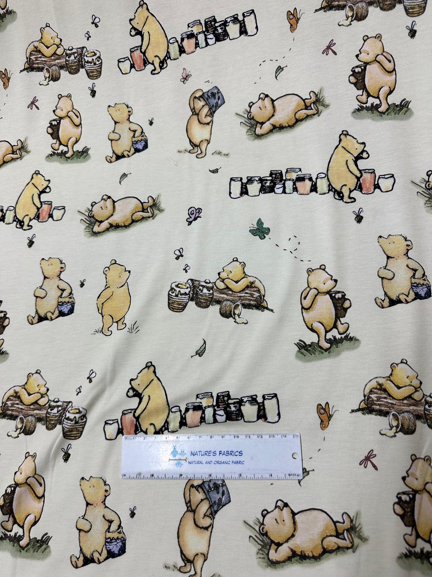 Winnie the Pooh and Honey Pots on Cream Bamboo/Spandex Jersey Fabric - Nature's Fabrics