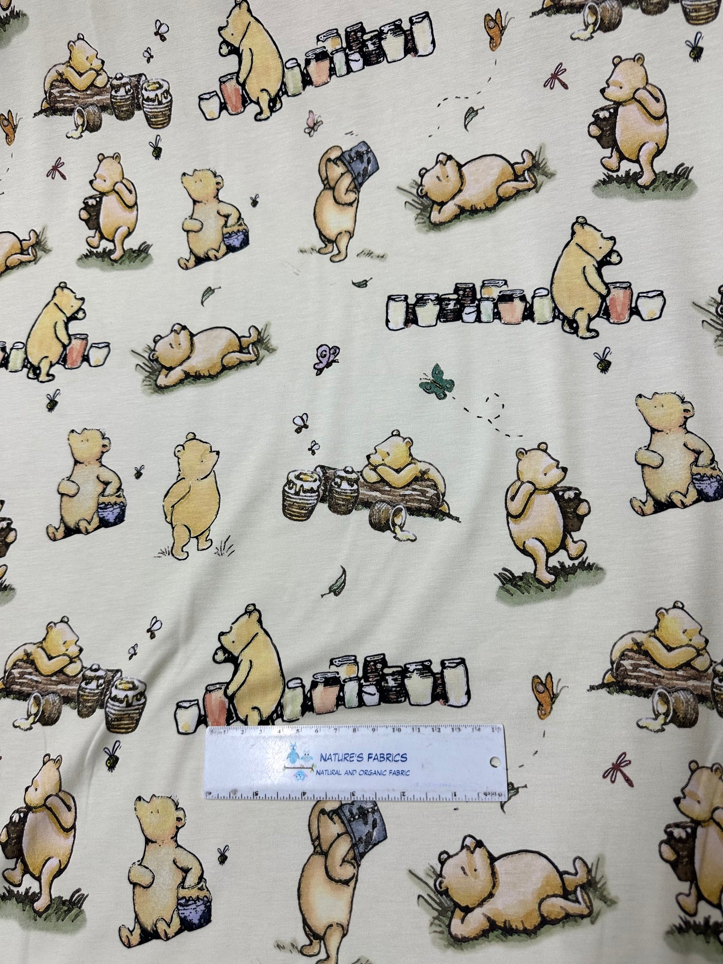 Winnie the Pooh and Honey Pots on Cream Bamboo/Spandex Jersey Fabric - Nature's Fabrics