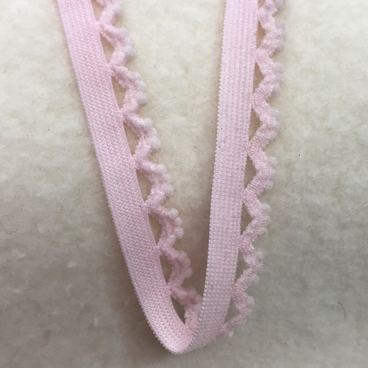 Nature's Fabrics light pink decorative lace trim with a scalloped edge