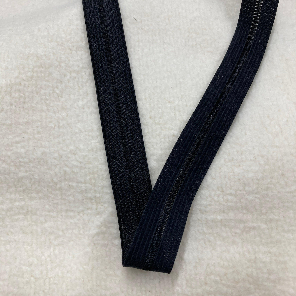 Nature's Fabrics black elastic band on a white textured background