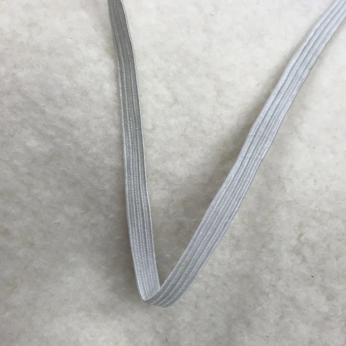 A close-up of light grey elastic fabric band from Nature's Fabrics on a white background.