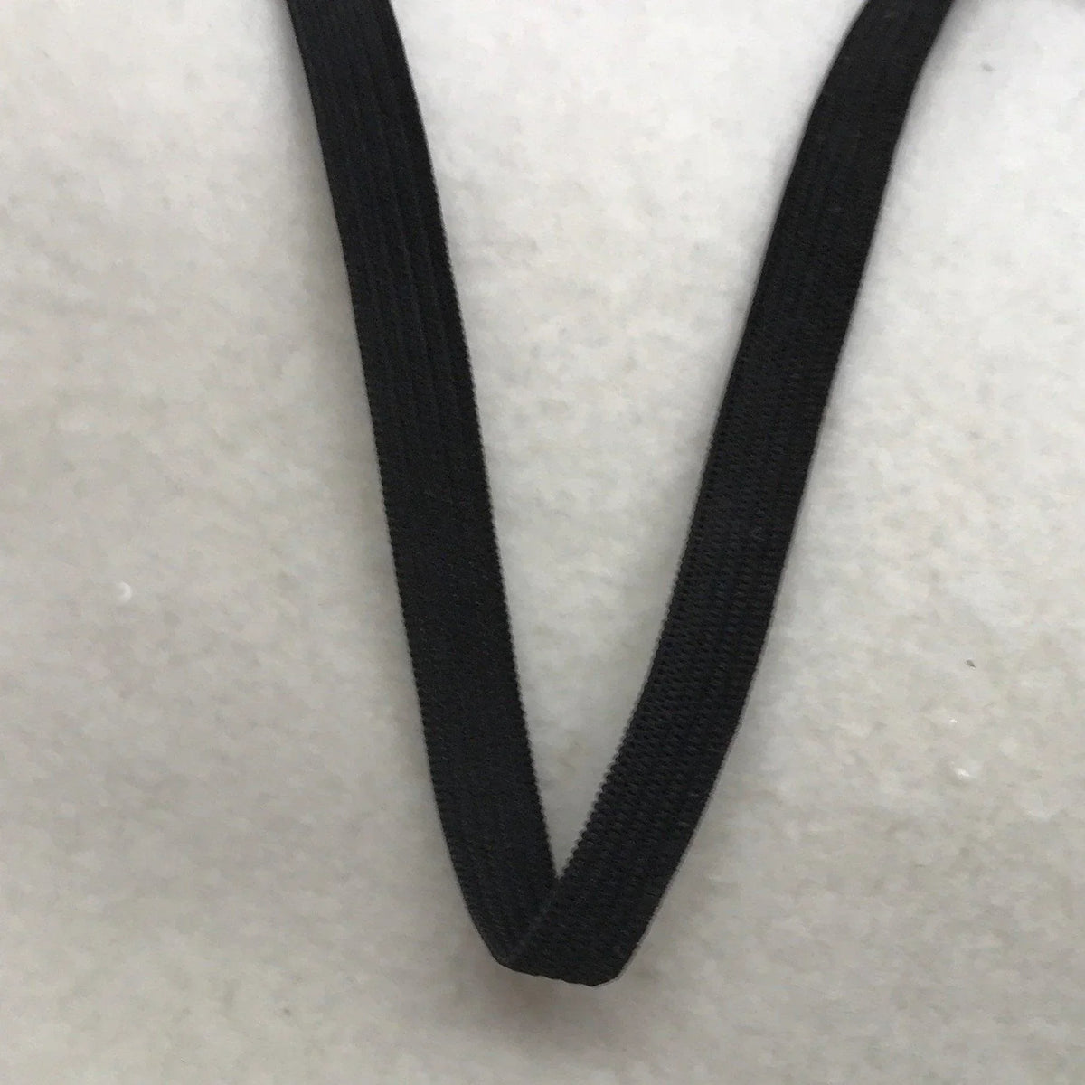 Close-up of a black elastic band from Nature's Fabrics on a white background