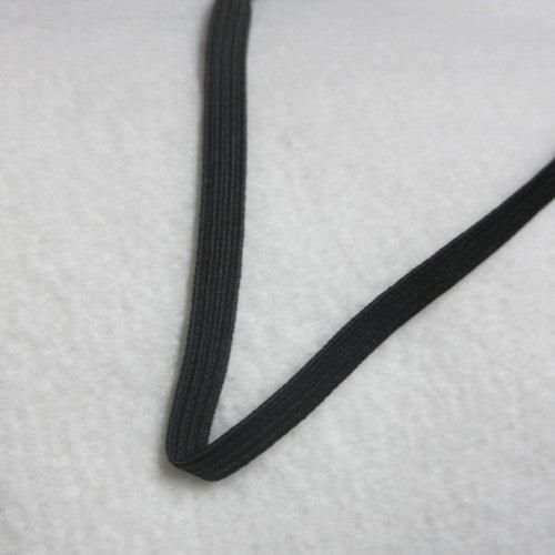 Black Nature's Fabrics elastic band on a white textured background