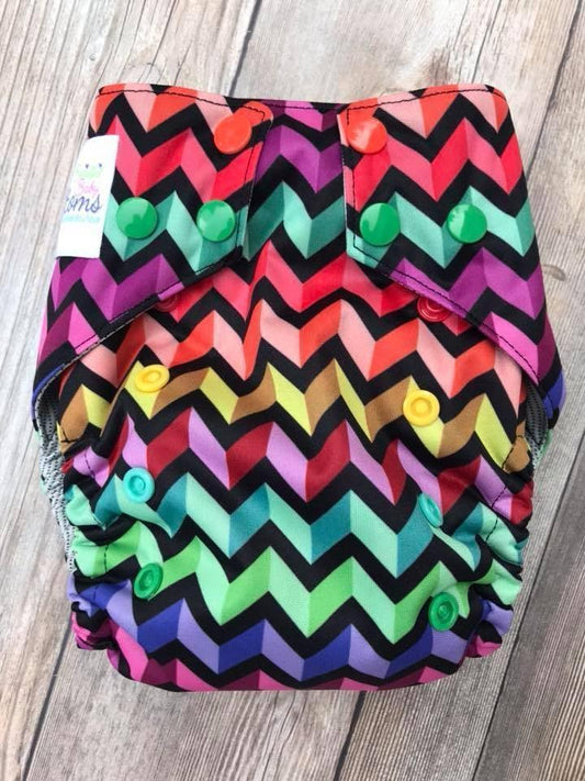Nature's Fabrics rainbow chevron pattern reusable cloth diaper with colorful snap buttons.
