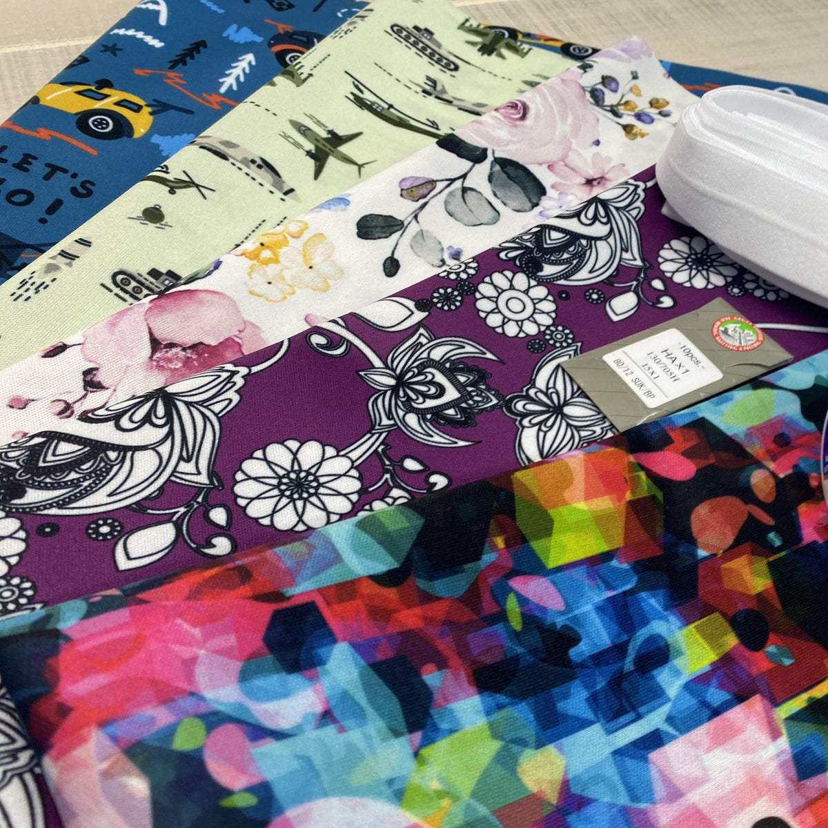 Assorted patterned Nature's Fabrics textile rolls in floral and geometric designs.