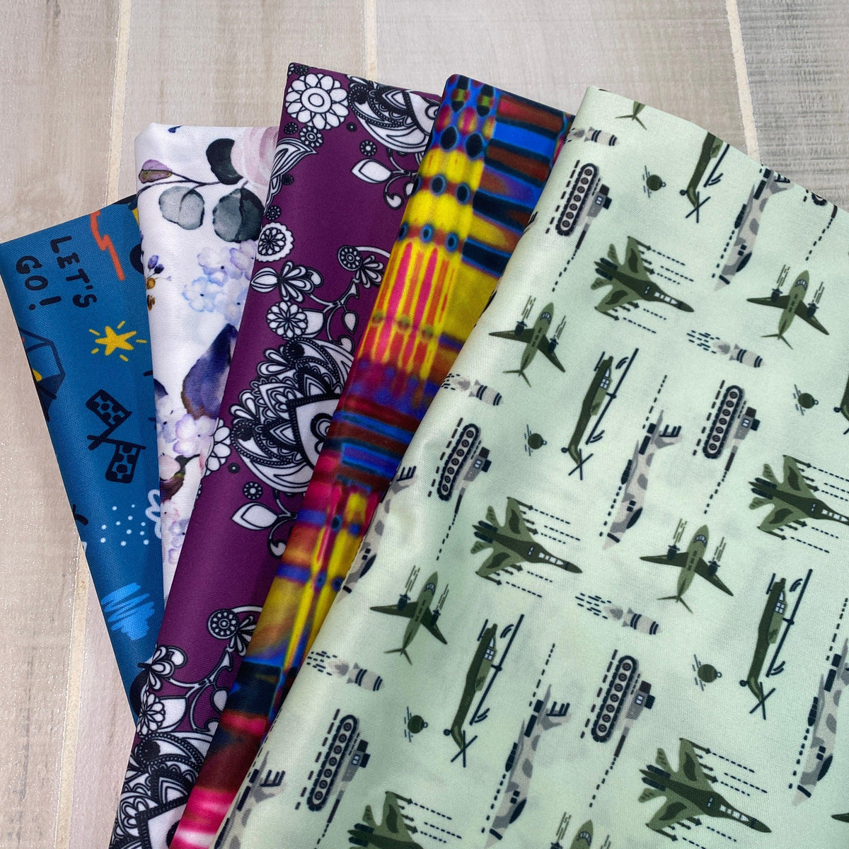 Variety of patterned Nature's Fabrics cotton fabrics in blue, purple, and green prints.