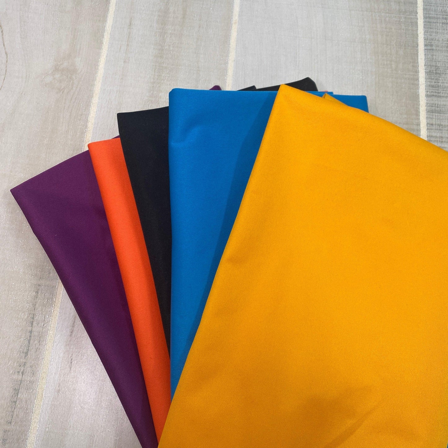 Nature's Fabrics premium natural fabric swatches in purple, orange, black, blue, and yellow.