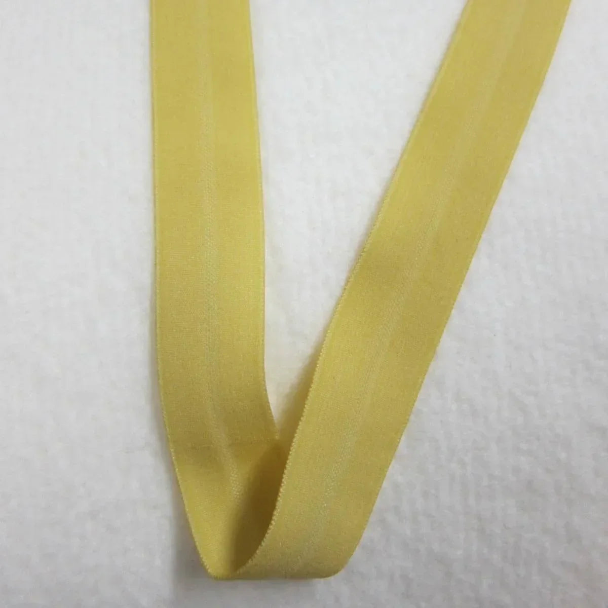Yellow elastic band from Nature's Fabrics on a white textured background