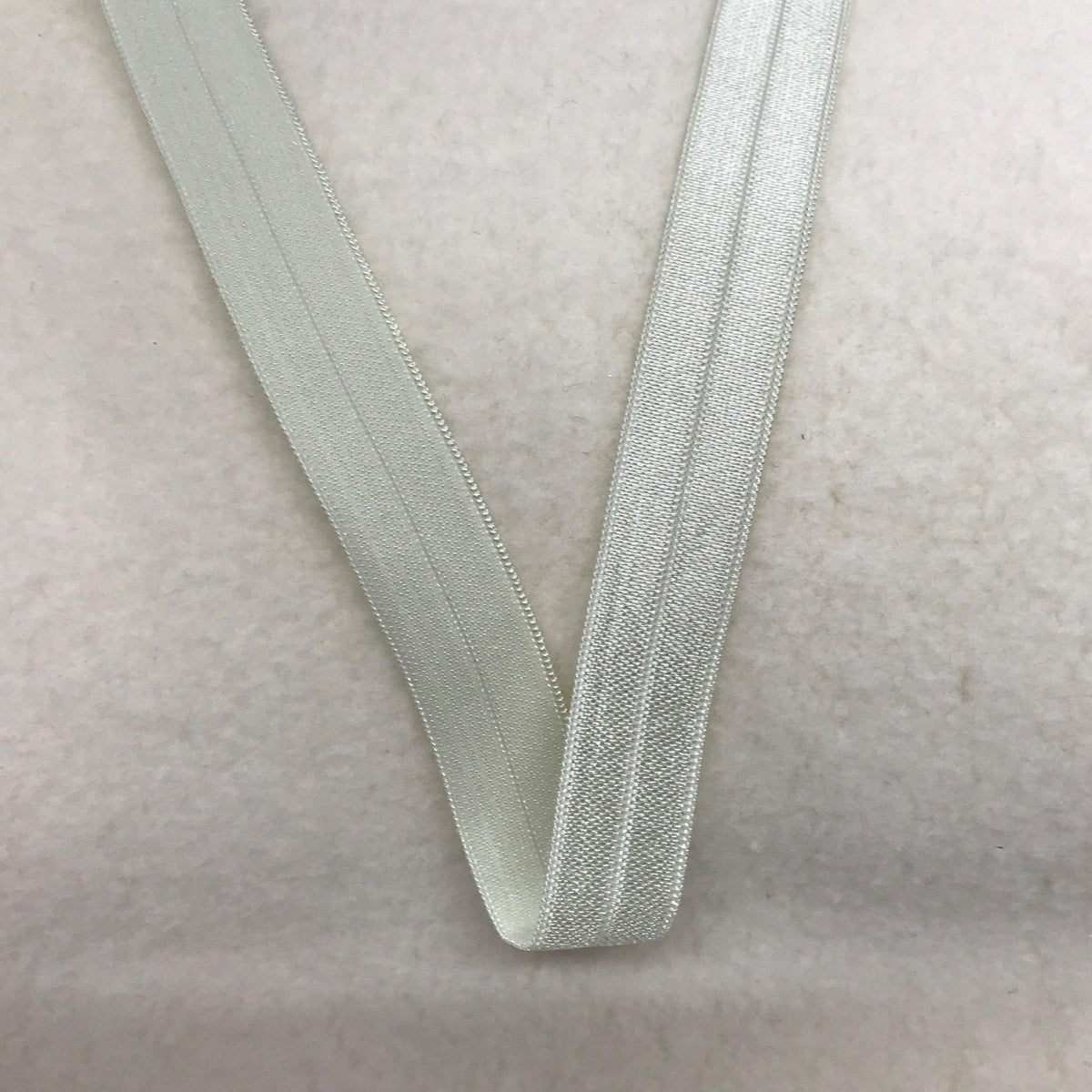 Nature's Fabrics white ribbed elastic sewing trim on a neutral background