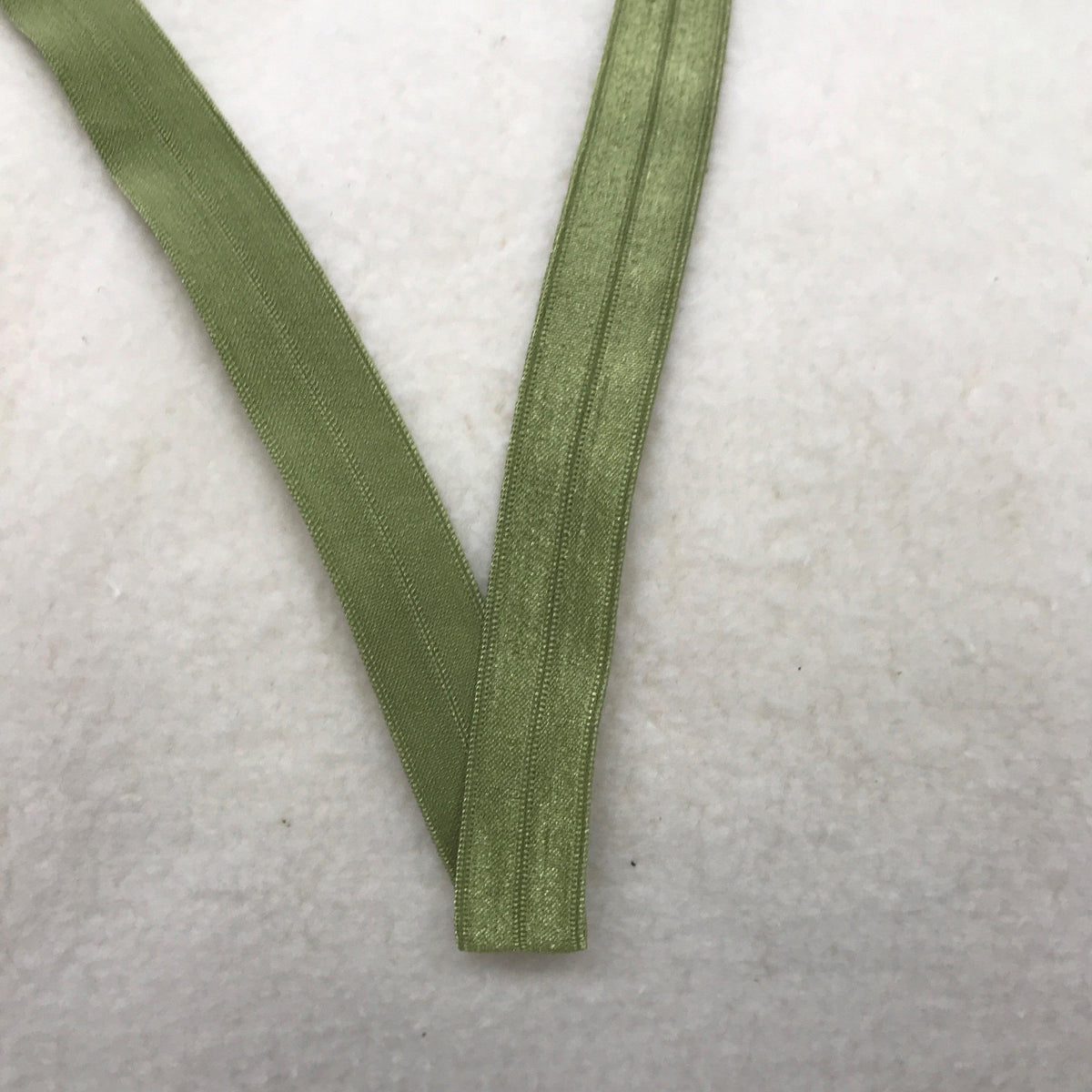 Sage green ribbed elastic band from Nature's Fabrics on white textured background