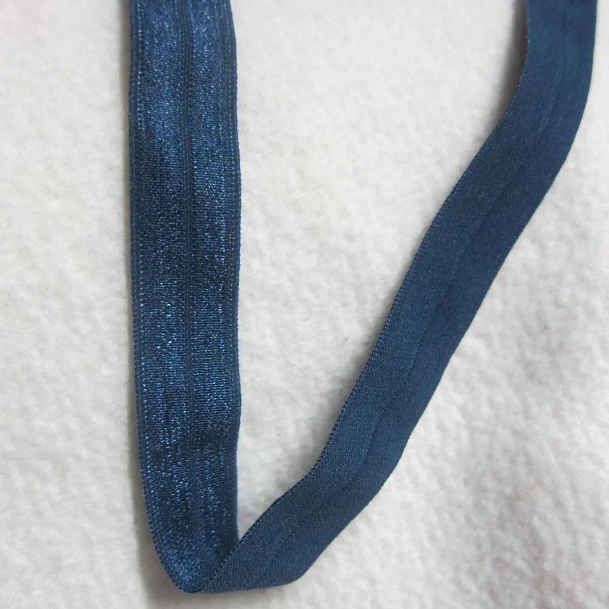 Nature's Fabrics blue elastic band on a white textured background