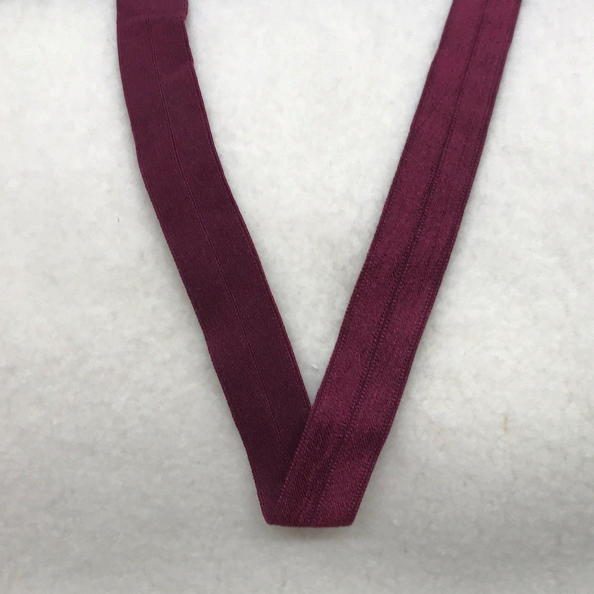Nature's Fabrics burgundy elastic band folded in a V-shape on a white background