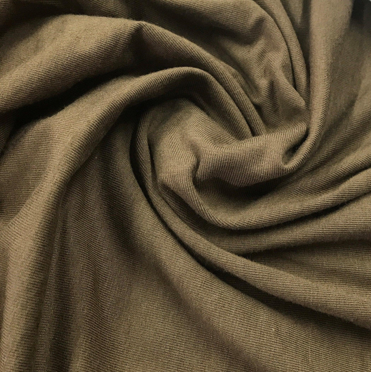Olive green organic cotton jersey fabric draped in swirls from Nature's Fabrics