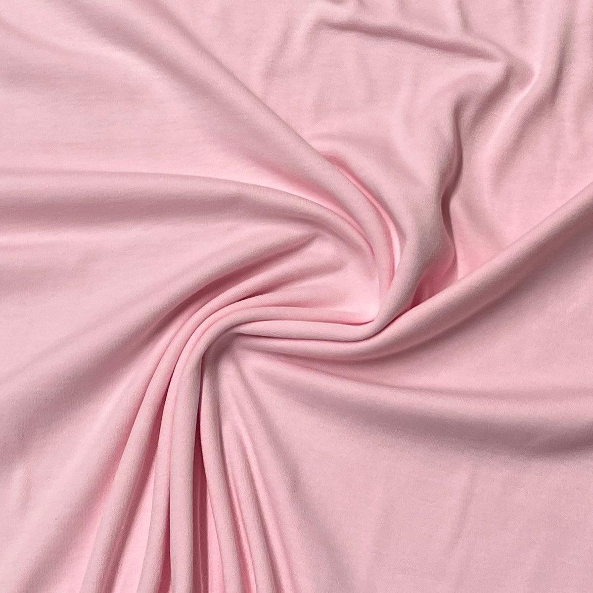 Soft pink organic cotton fabric draped in folds from Nature's Fabrics