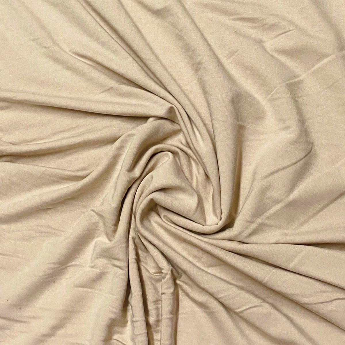 Beige natural fabric by Nature's Fabrics draped in soft, swirling folds.