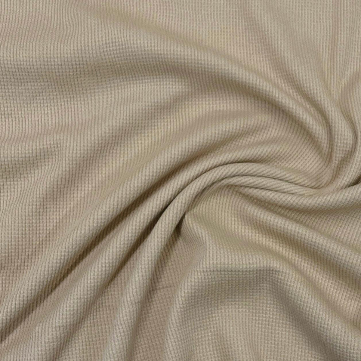 Nature's Fabrics beige waffle knit organic cotton fabric draped in soft folds