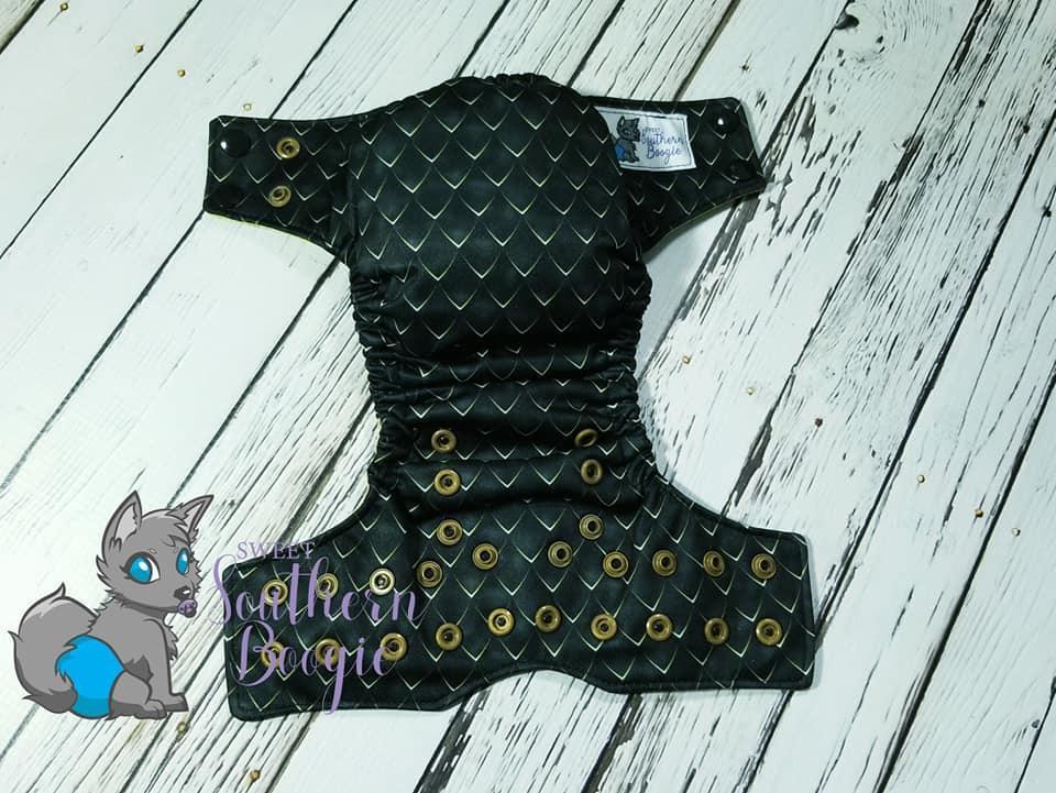 Sweet Southern Boogie black scale pattern reusable cloth diaper on white wood background