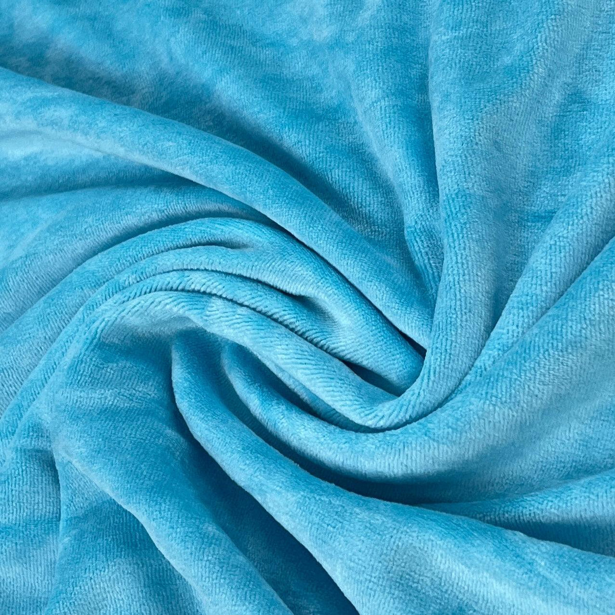 Close-up of draped light blue plush velvet fabric from Nature's Fabrics.