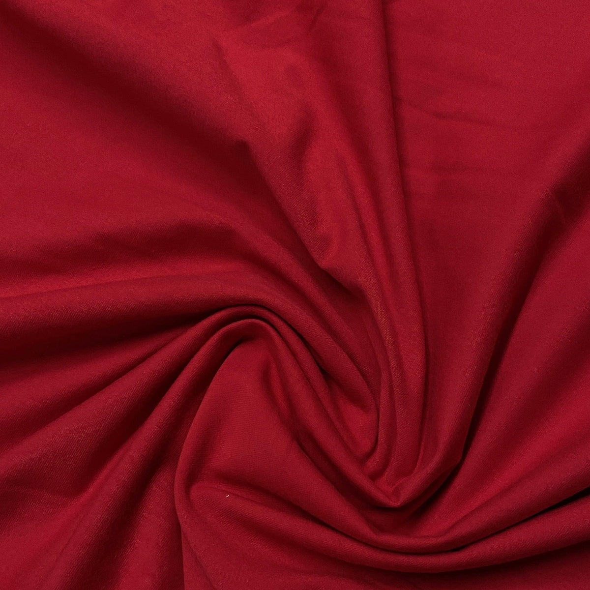 Deep red fabric from Nature's Fabrics draped in a spiral swirl pattern