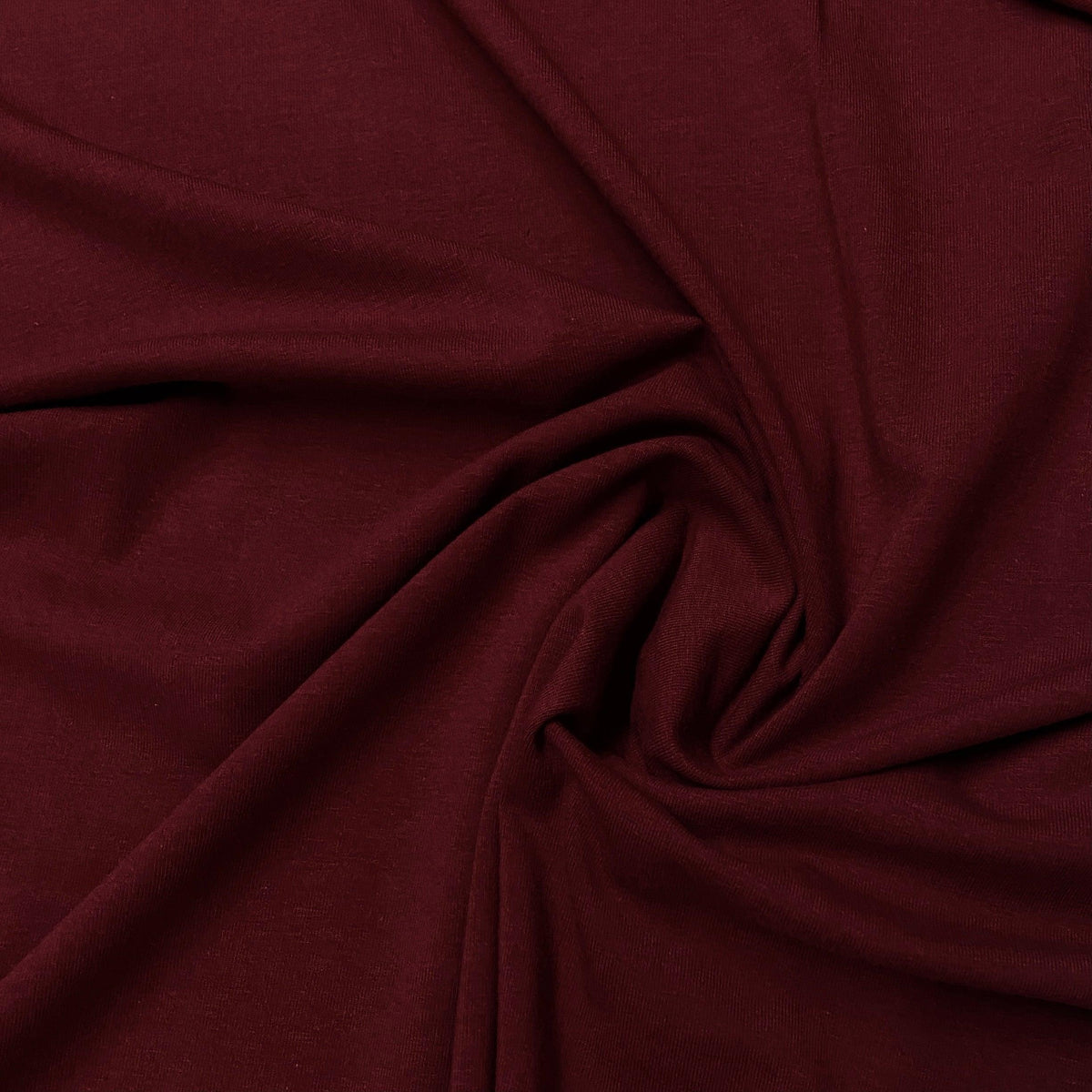 Deep burgundy premium natural fabric draped in folds from Nature's Fabrics