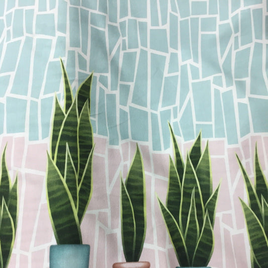 Nature's Fabrics textile featuring green snake plants against a blue and pink mosaic background