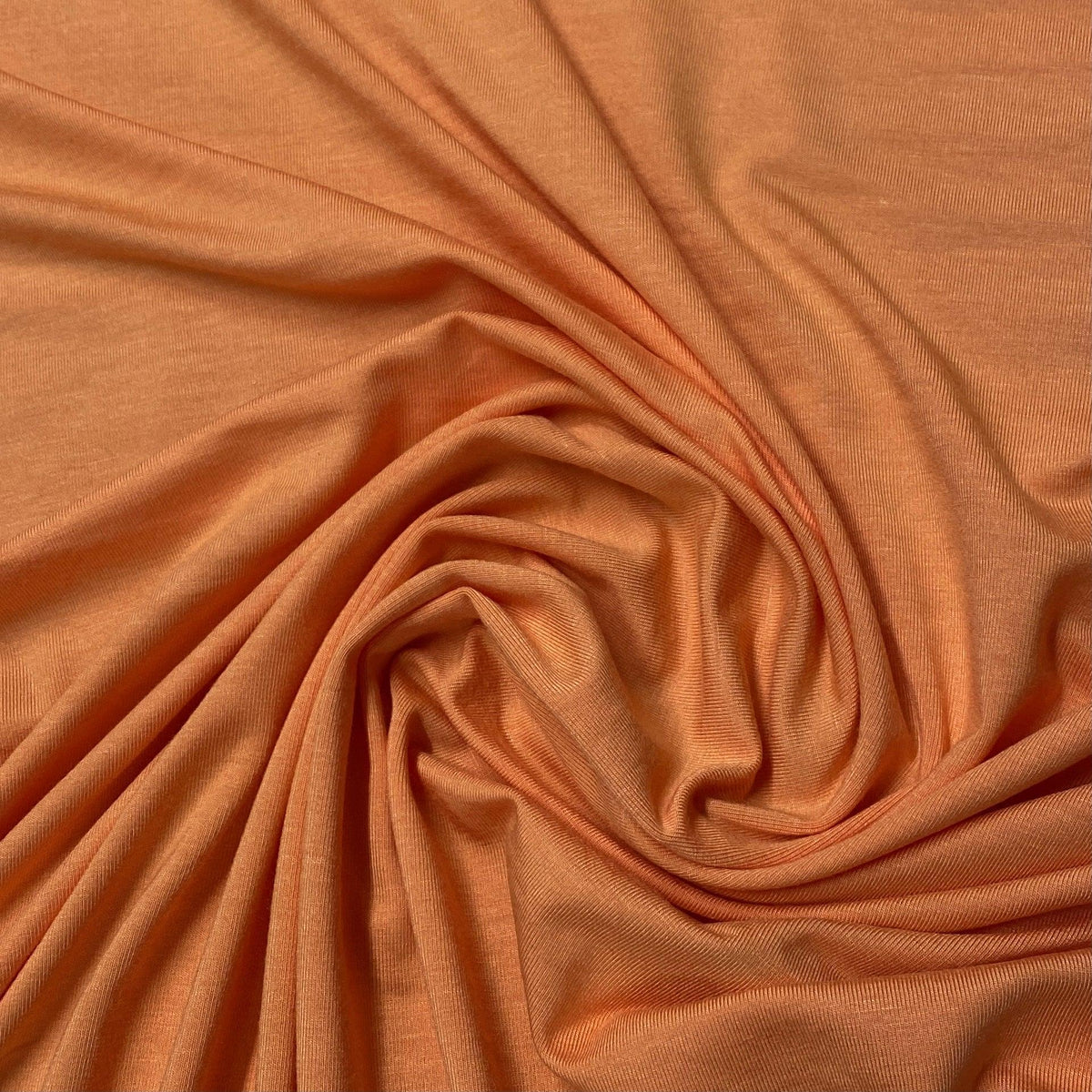 Close-up of draped orange natural fabric from Nature's Fabrics