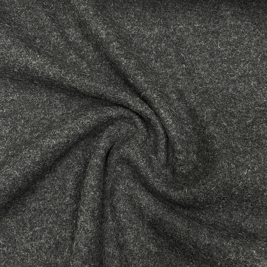 Close-up of charcoal grey wool fabric draped in swirls from Nature's Fabrics.