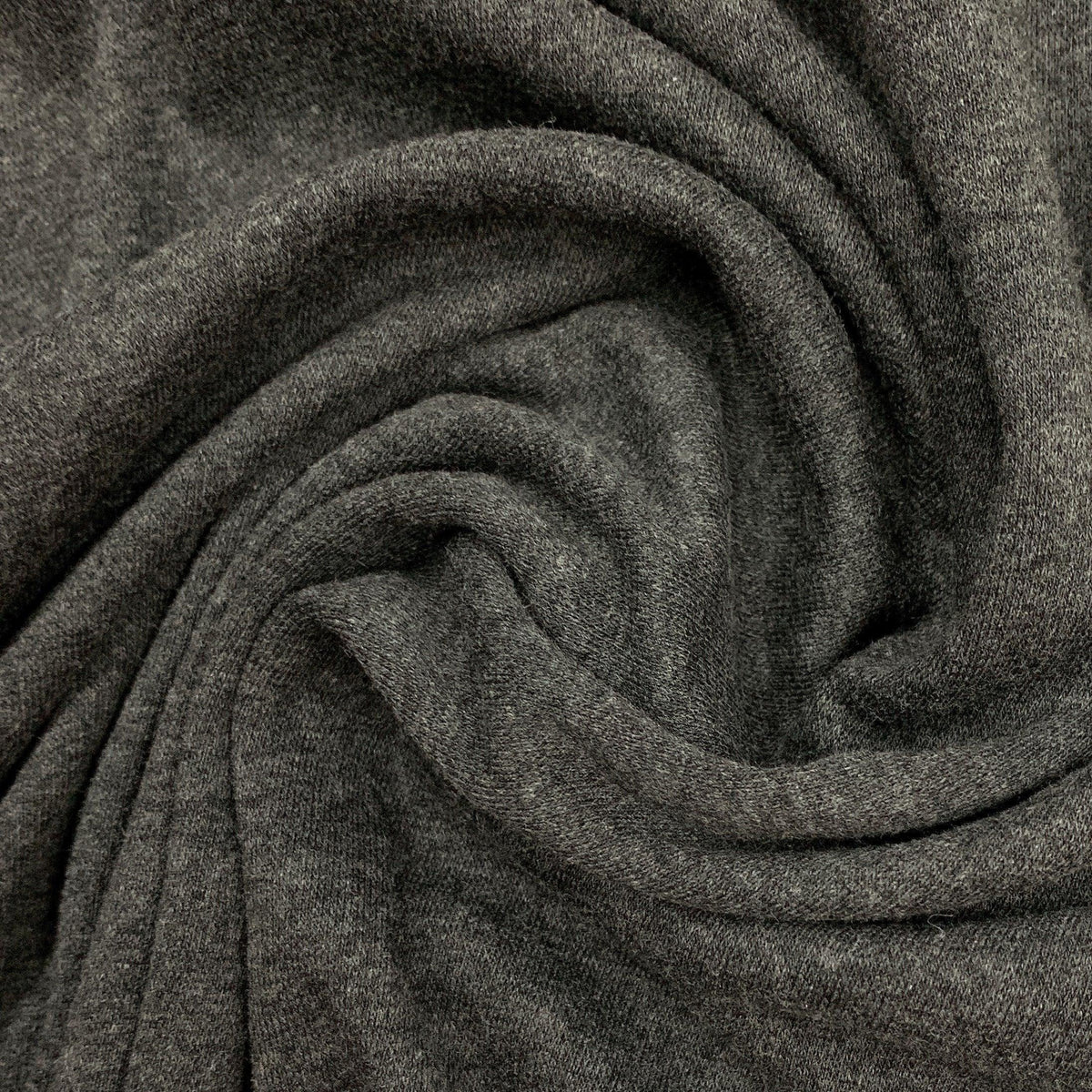 Close-up of charcoal grey natural fabric draped in folds from Nature's Fabrics
