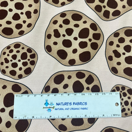 Nature's Fabrics organic fabric with brown leopard-style spots and a measuring ruler.