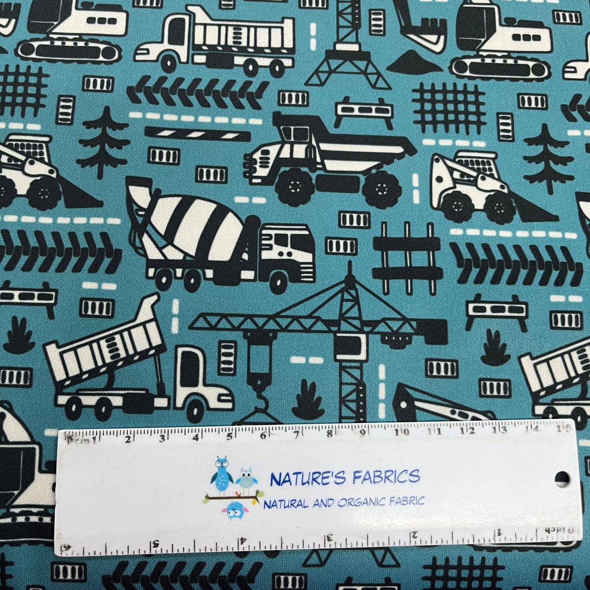 Nature's Fabrics teal organic cotton fabric with a black and white construction vehicle print.