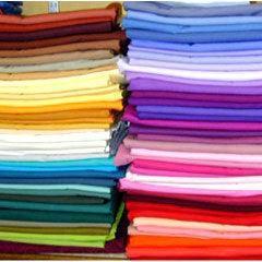 Stacks of colorful premium natural fabric bolts from Nature's Fabrics