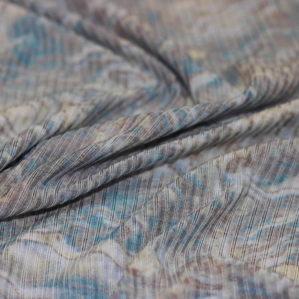 Close-up of Nature's Fabrics draped blue and grey patterned textured fabric.