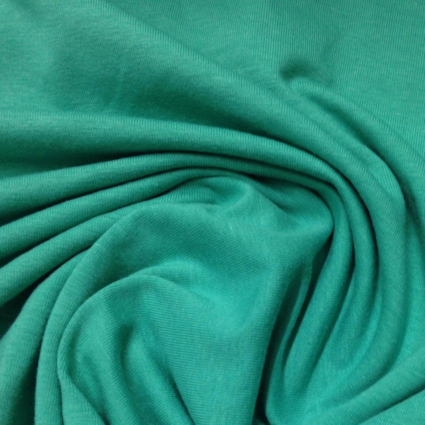 Close-up of draped green organic cotton fabric from Nature's Fabrics.