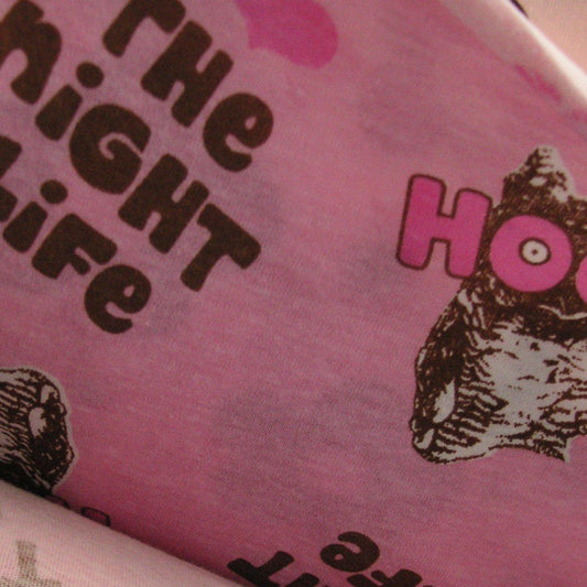 Close-up of pink Nature's Fabrics material with dark brown text and illustrative graphics.