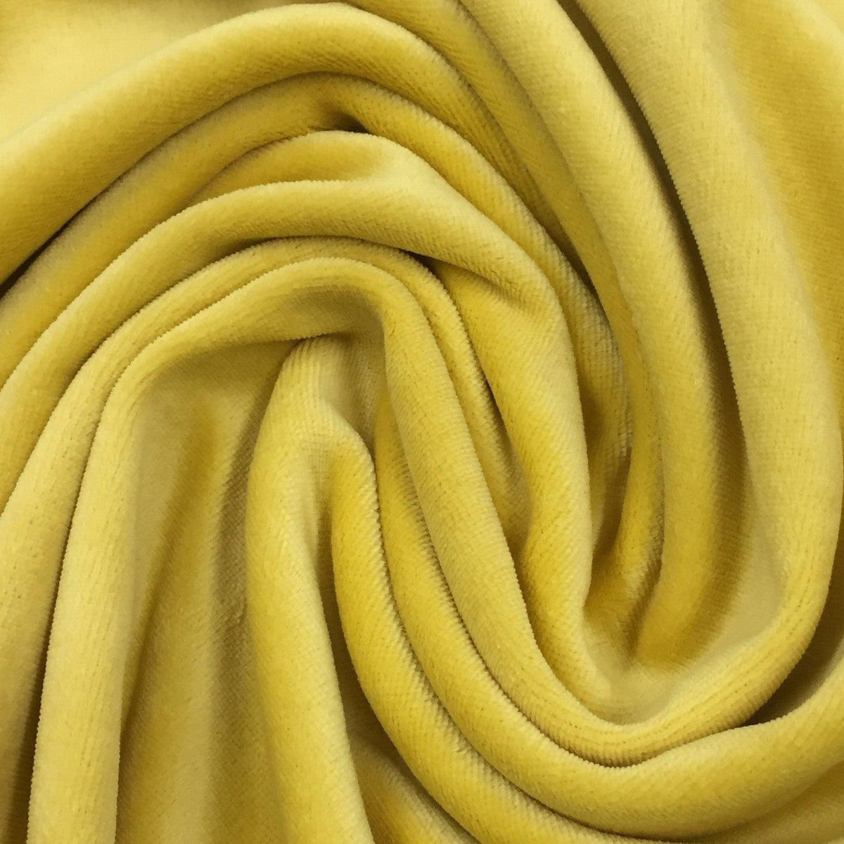 Close-up of draped yellow velvet fabric from Nature's Fabrics.